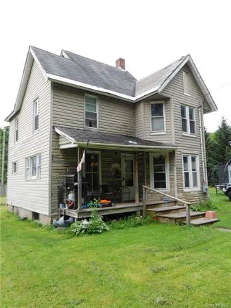 a view of a house with a yard and sitting area