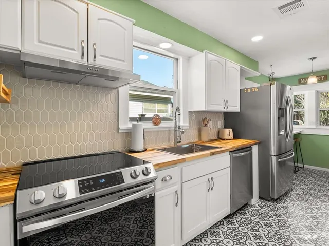 a kitchen with stainless steel appliances granite countertop a sink stove and cabinets