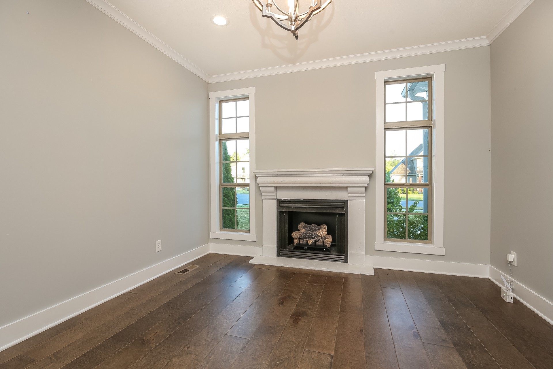 259 Harrowgate Drive Clarksville, TN 37043 - Photo 16 of 27 an empty room with wooden floor fireplace and windows