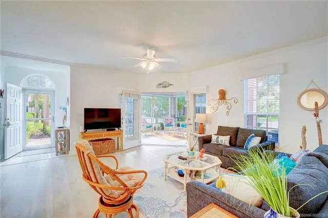a living room with furniture a flat screen tv and a large window