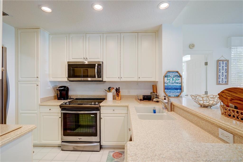 411 Northeast Plantation Road, Unit 511 Stuart, FL 34996 - Photo 17 of 45 a kitchen with a stove a sink and a microwave