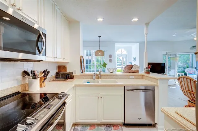 a kitchen with kitchen island granite countertop a sink stove and cabinets