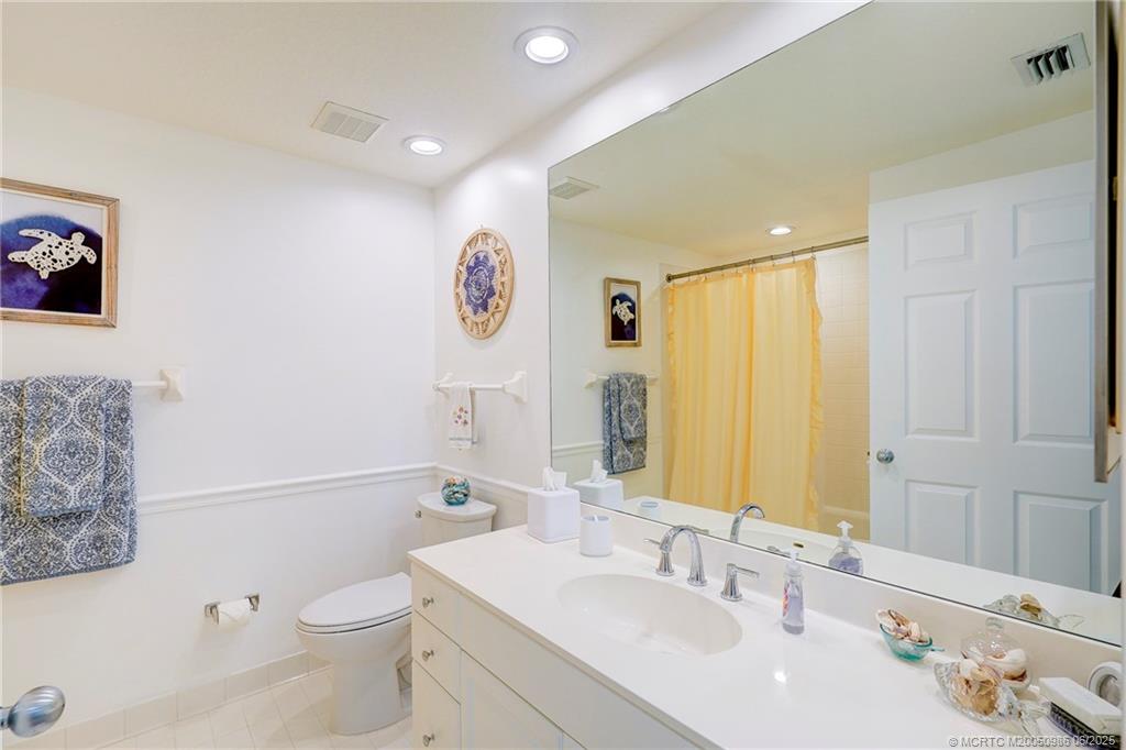 411 Northeast Plantation Road, Unit 511 Stuart, FL 34996 - Photo 21 of 45 a bathroom with a toilet sink and mirror