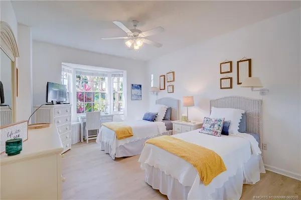 a bedroom with two beds and a chandelier