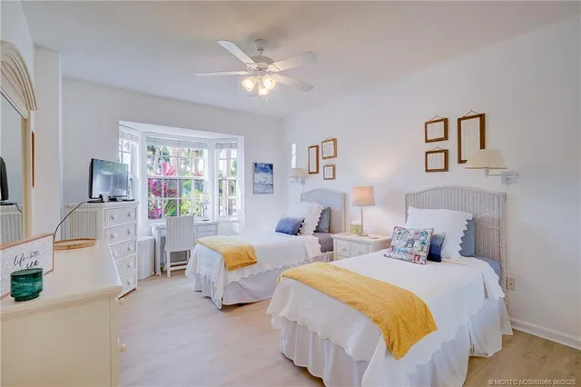 a bedroom with two beds and a chandelier