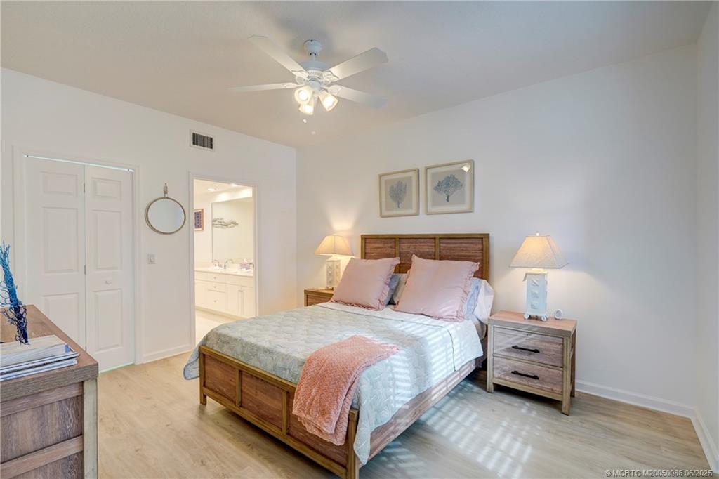 411 Northeast Plantation Road, Unit 511 Stuart, FL 34996 - Photo 29 of 45 a bedroom with a bed and a chandelier