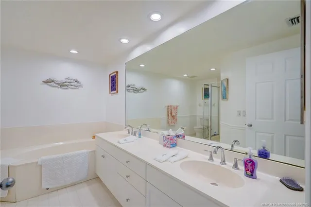a bathroom with a tub sink and mirror