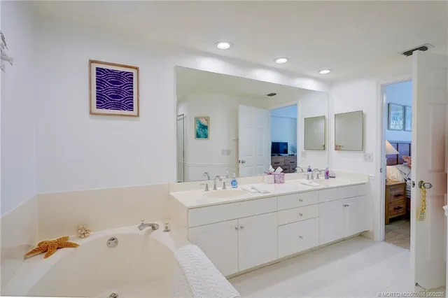 a view of a double vanity sink mirror and tub