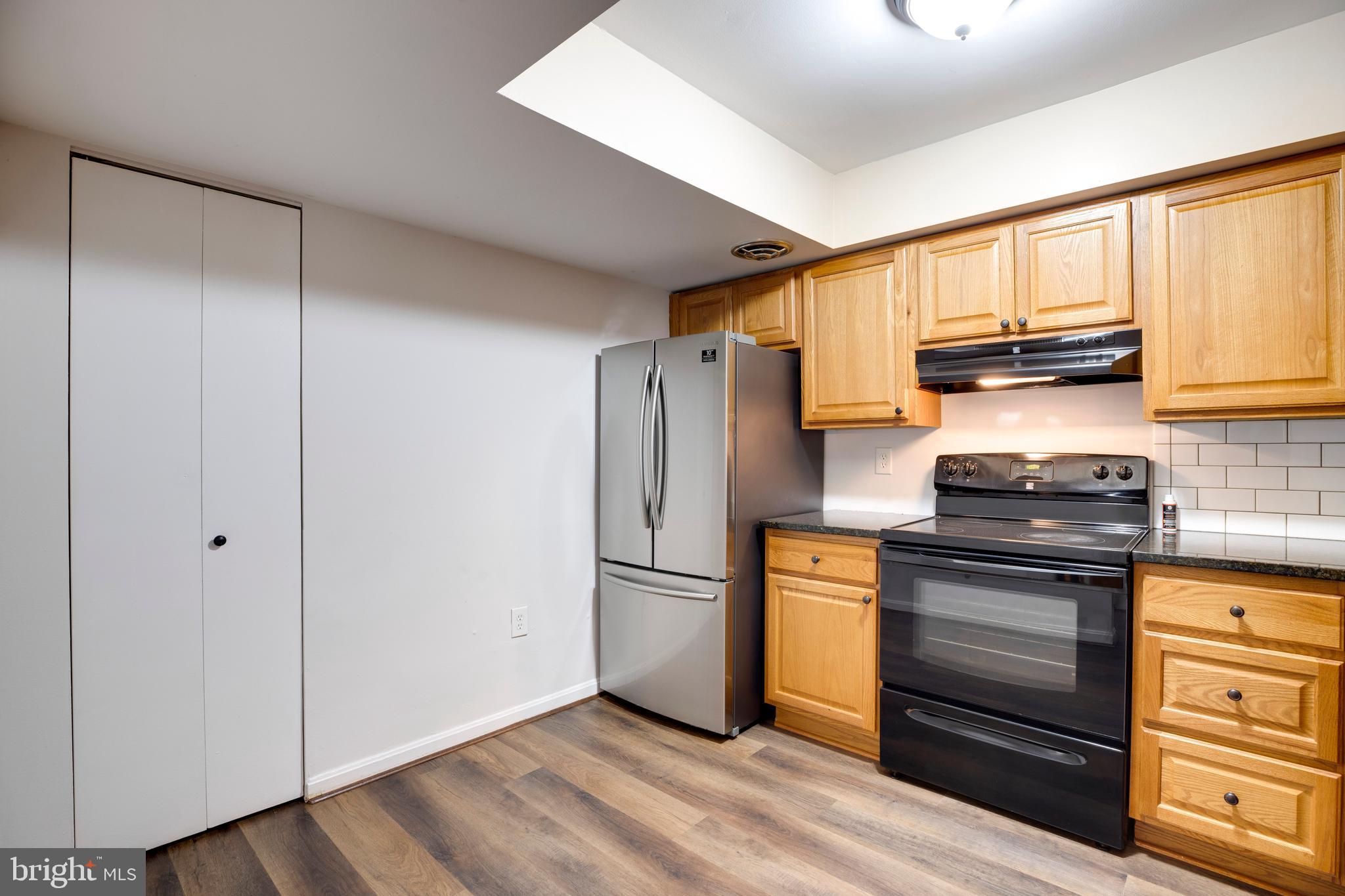 6421 Birch Leaf Court, Unit 36A Burke, VA 22015 - Photo 12 of 26 a kitchen with granite countertop a refrigerator stove and a sink