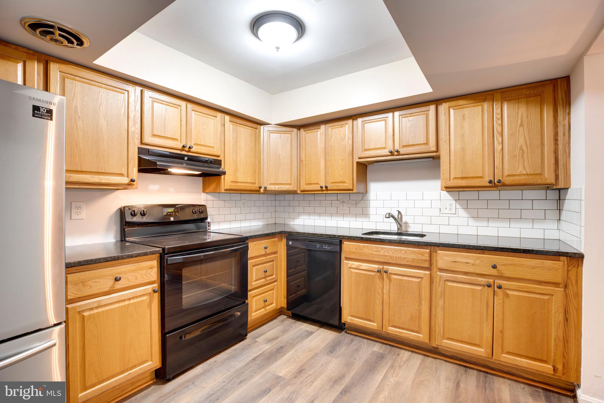 6421 Birch Leaf Court, Unit 36A Burke, VA 22015 - Photo 13 of 26 a kitchen with granite countertop wooden cabinets stainless steel appliances a sink and a window