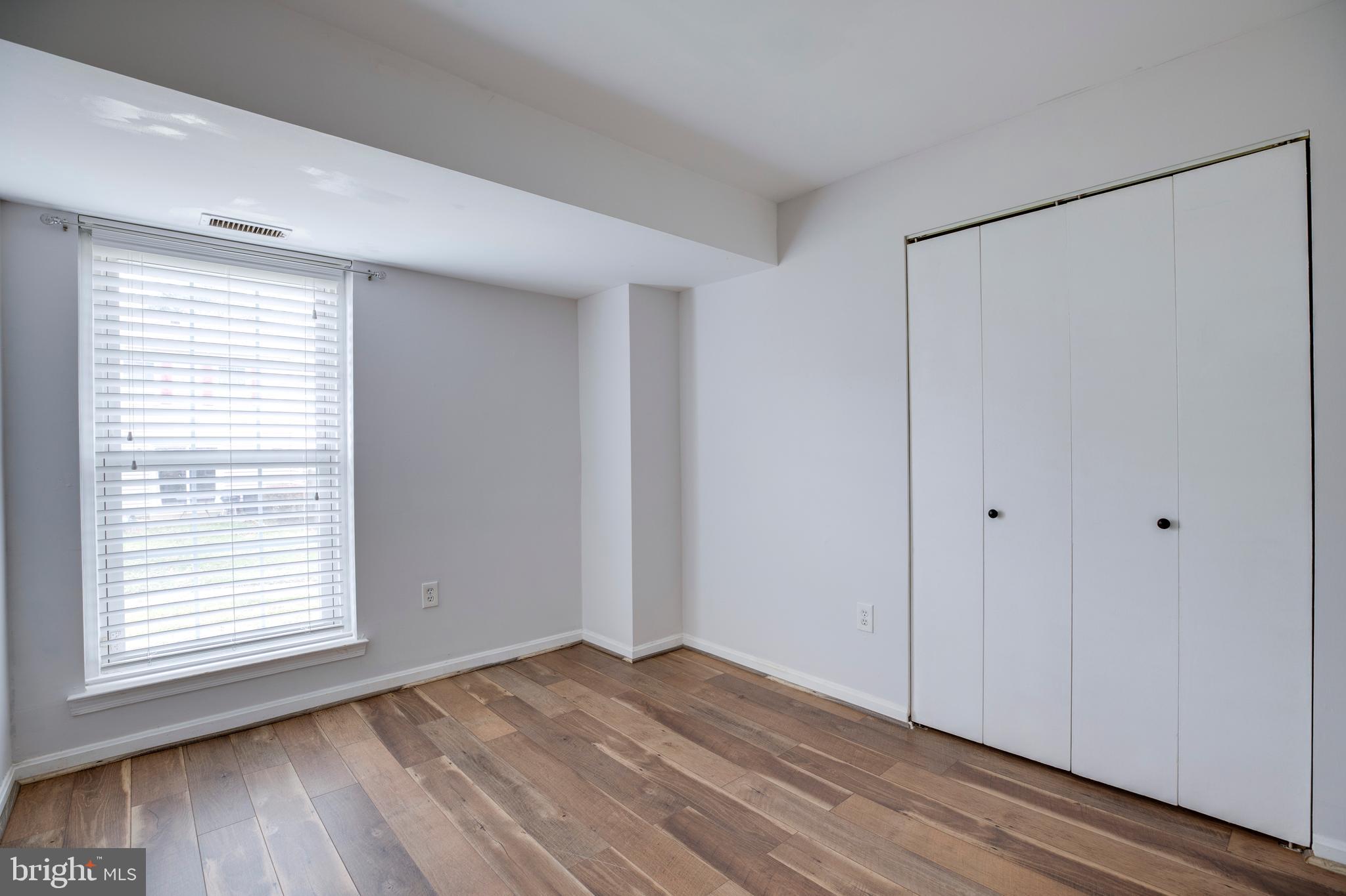 6421 Birch Leaf Court, Unit 36A Burke, VA 22015 - Photo 18 of 26 a view of an empty room with wooden floor and a window