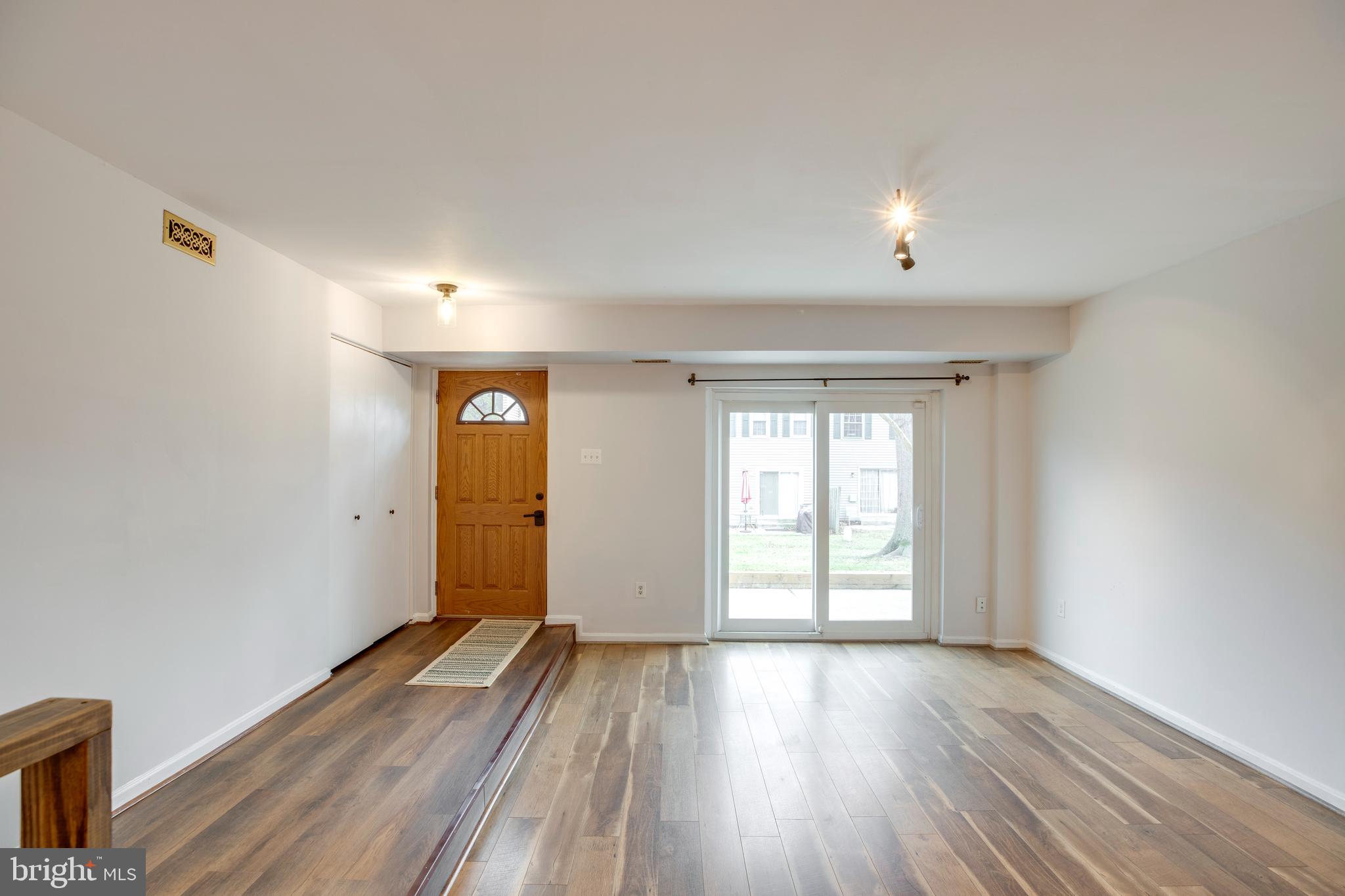 6421 Birch Leaf Court, Unit 36A Burke, VA 22015 - Photo 4 of 26 an empty room with wooden floor and windows