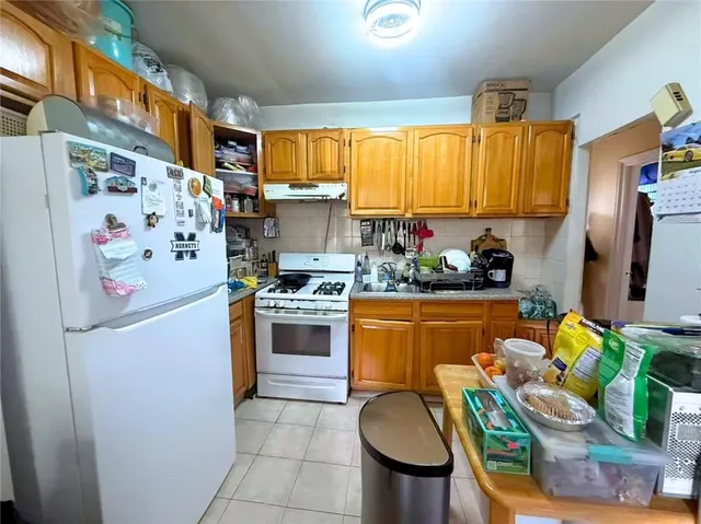 a kitchen with stainless steel appliances a refrigerator sink and a refrigerator
