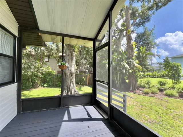 a view of a room with wooden floor and a floor to ceiling window