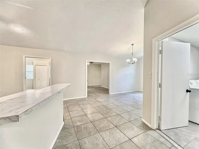 a kitchen with stainless steel appliances kitchen island granite countertop a stove a sink and white cabinets
