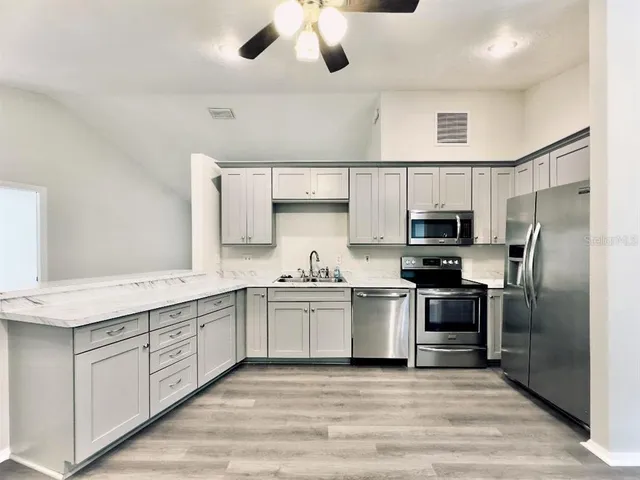 an empty room that has a window and a chandelier