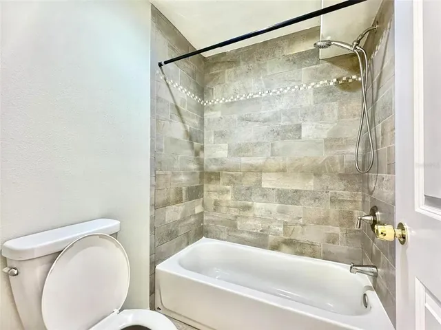 a view of a livingroom with a chandelier fan and windows