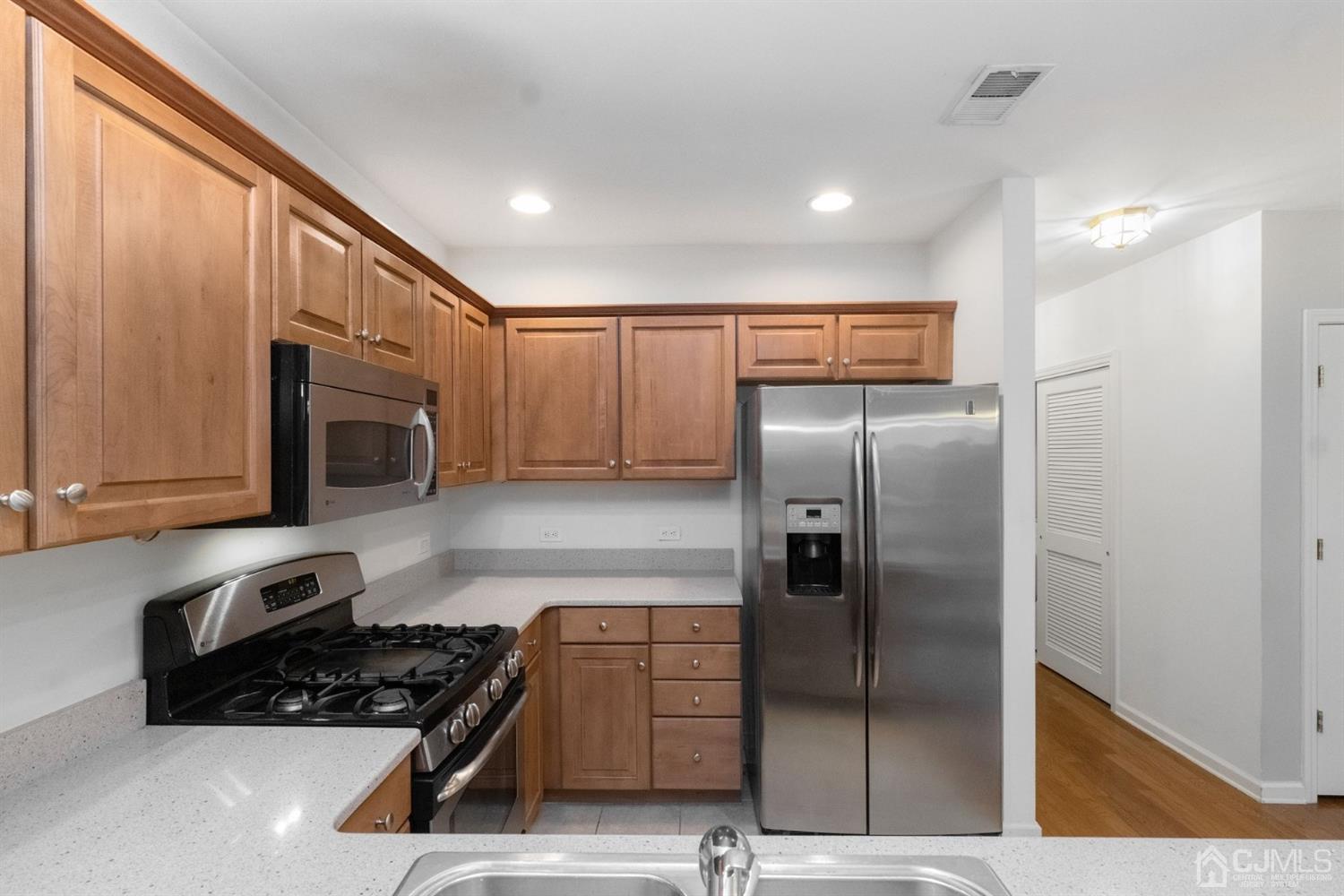 368 Rector Street, Unit 422 Perth Amboy, NJ 08861 - Photo 9 of 17 a kitchen with stainless steel appliances granite countertop a refrigerator and a stove top oven