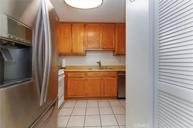 a kitchen with stainless steel appliances granite countertop a refrigerator and a stove top oven