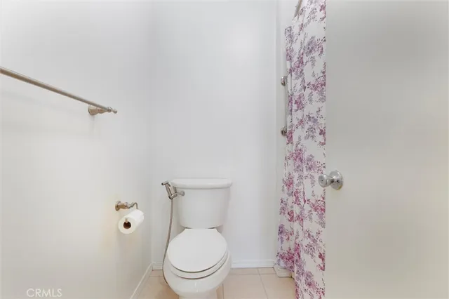 a white toilet sitting next to a shower curtain