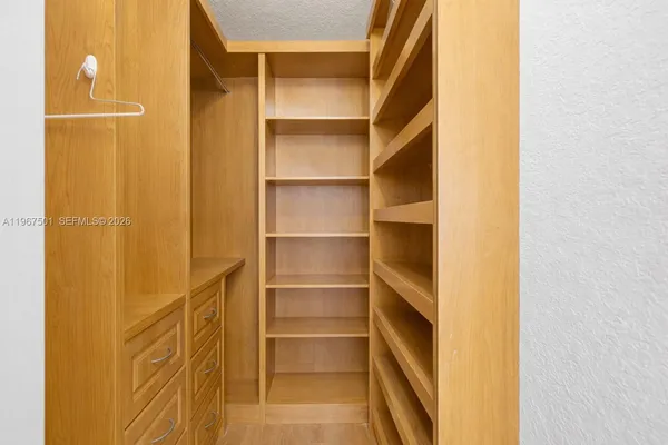 a view of walk in closet with empty racks