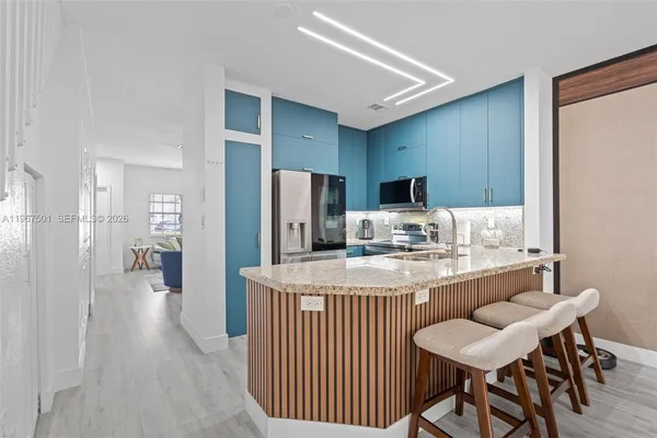 a kitchen with refrigerator and chairs