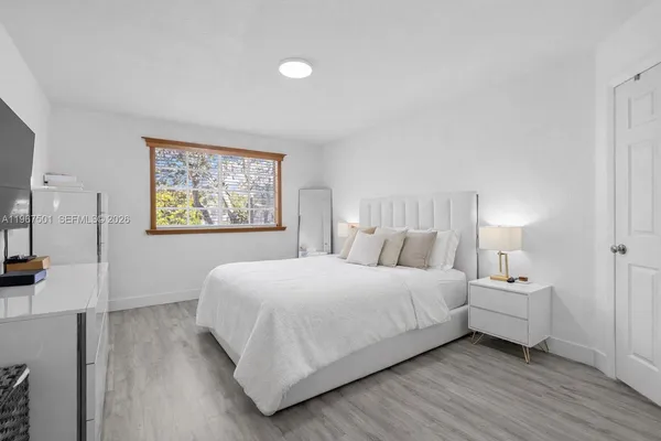 a bedroom with a bed and a painting on the wall
