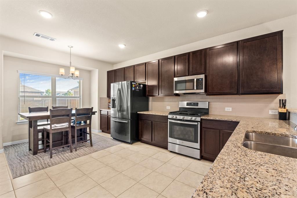 4207 Whispering Willow Way Arlington, TX 76005 - Photo 12 of 31 a kitchen with stainless steel appliances granite countertop a stove refrigerator sink and cabinets