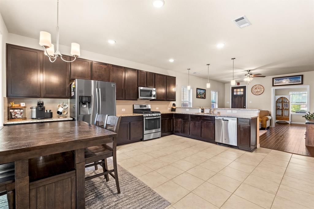 4207 Whispering Willow Way Arlington, TX 76005 - Photo 31 of 31 a kitchen with stainless steel appliances kitchen island granite countertop a sink counter space and cabinets