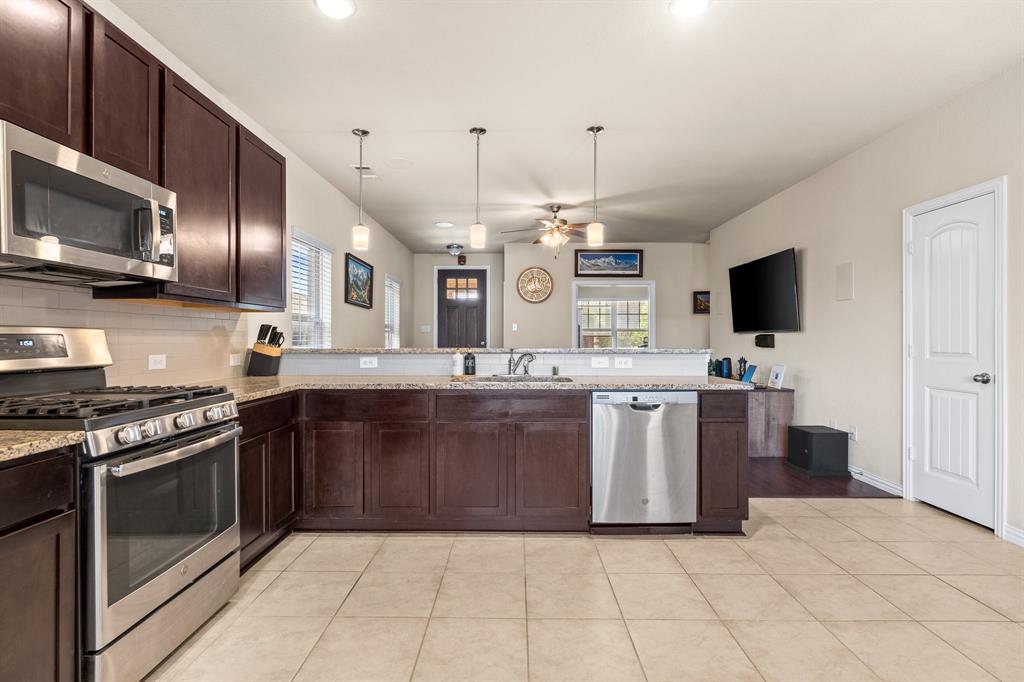 4207 Whispering Willow Way Arlington, TX 76005 - Photo 15 of 31 a large kitchen with stainless steel appliances granite countertop a stove and a sink