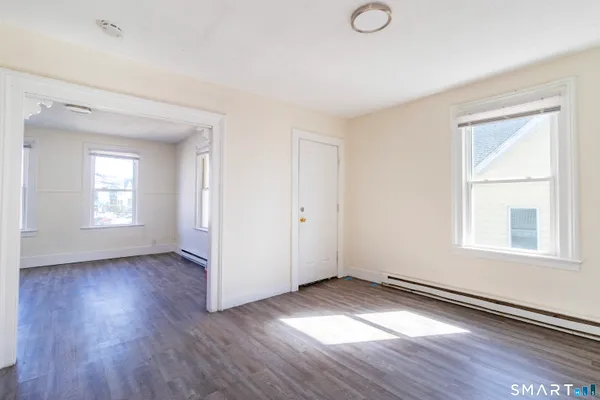 an empty room with wooden floor and windows
