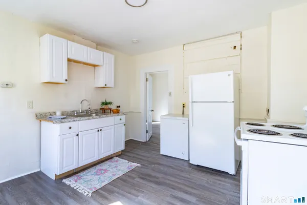 a kitchen with sink refrigerator and cabinets