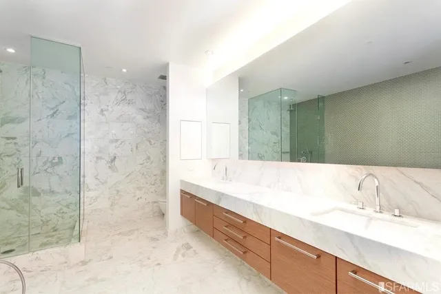 a bathroom with a granite countertop sink a mirror and a bathtub