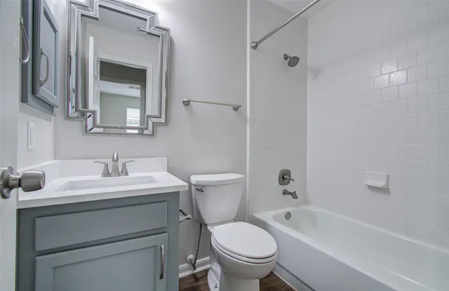 a bathroom with a sink toilet vanity and tub