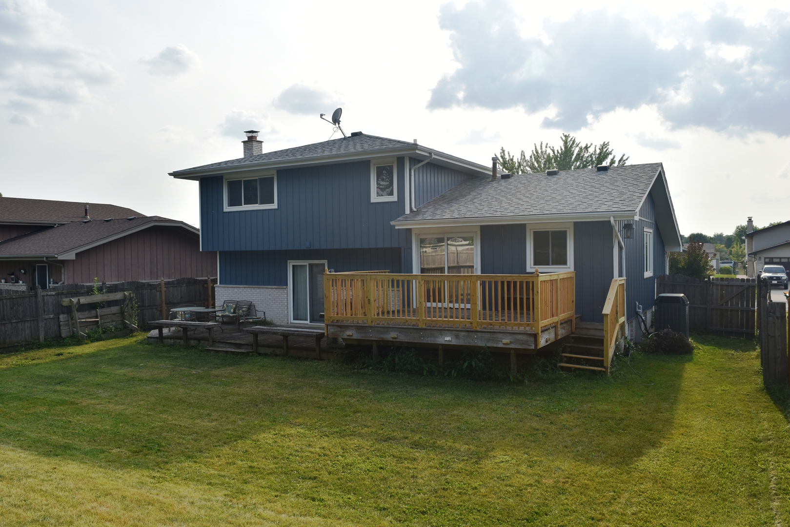 633 Gavin Avenue Romeoville, IL 60446 - Photo 28 of 33 a view of a house with a wooden deck and a floor to ceiling window