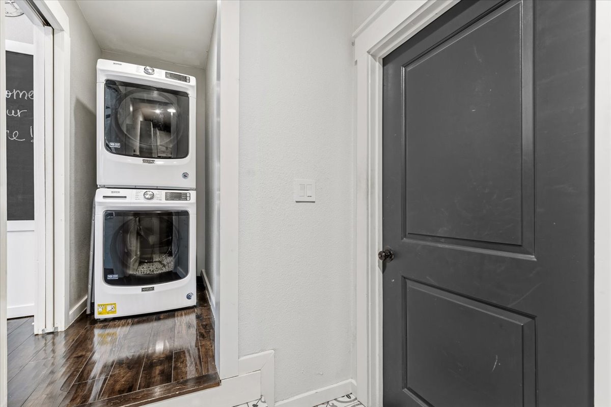 701 South Stuart Cove Leander, TX 78641 - Photo 27 of 40 Laundry area featuring wood-type flooring and stacked washer and dryer