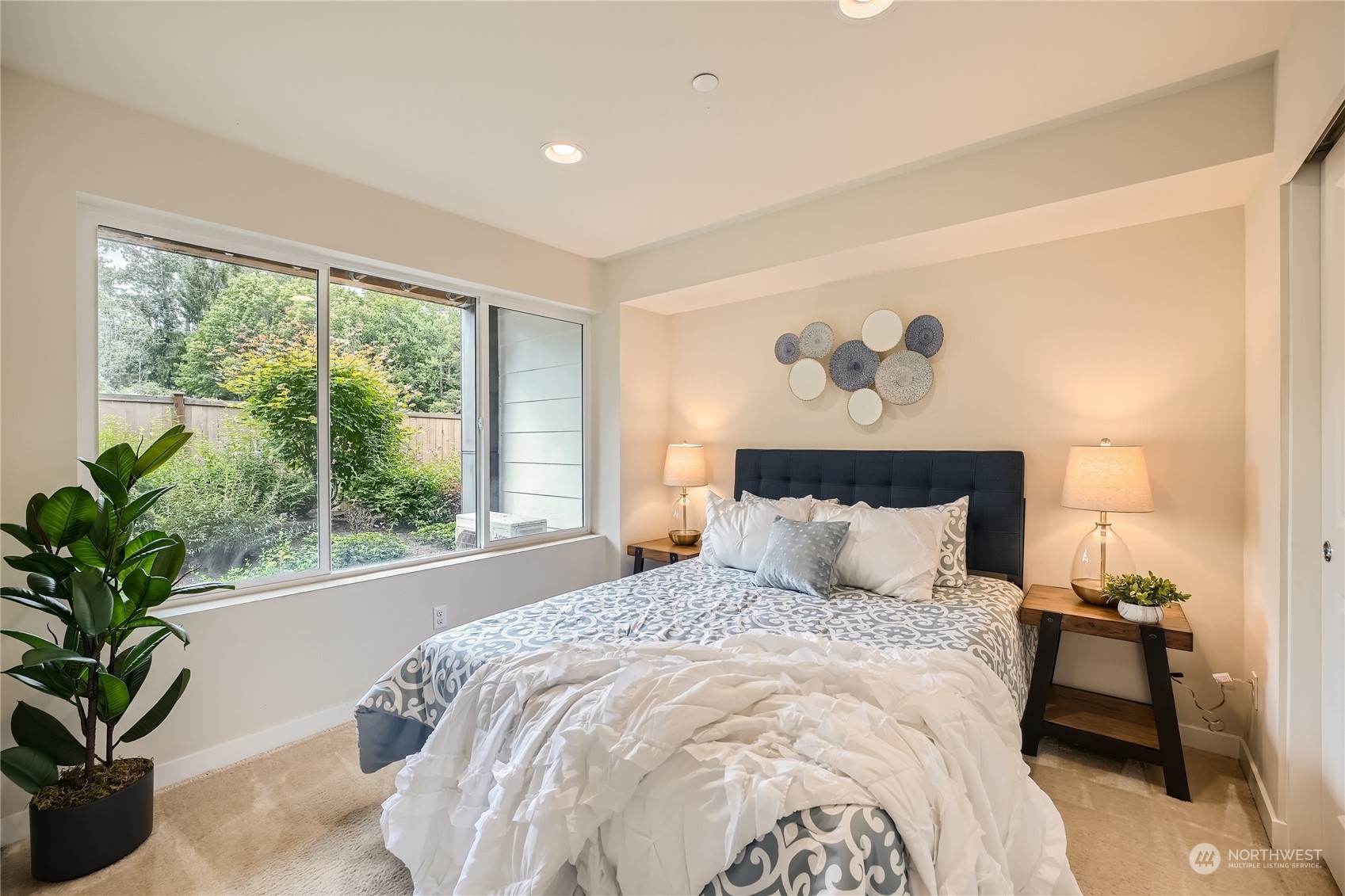 603 237th Street Southeast, Unit B Bothell, WA 98021 - Photo 22 of 27 a bedroom with a large bed and a potted plant