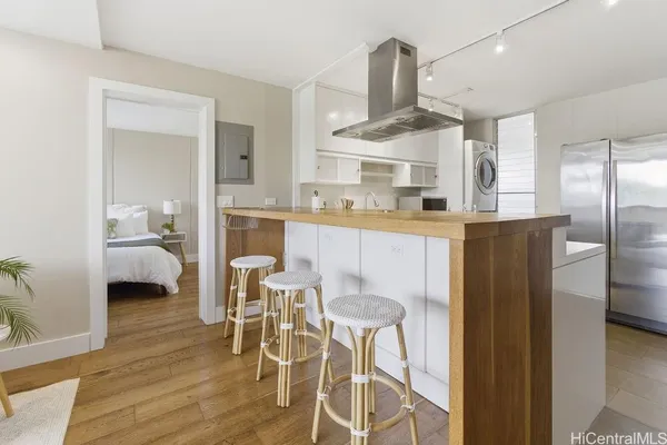 a kitchen with stainless steel appliances a dining table chairs stove and refrigerator
