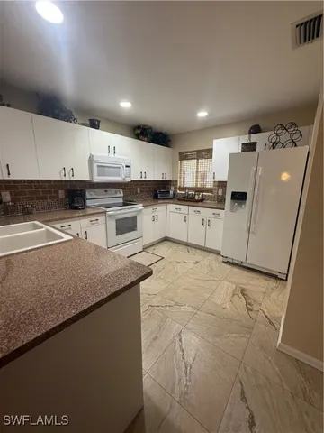 a kitchen with a sink window and stainless steel appliances