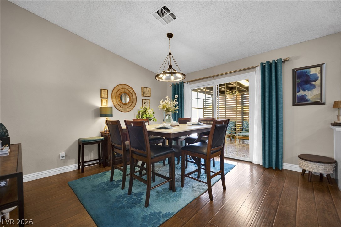 530 Grape Drive Henderson, NV 89015 - Photo 7 of 39 Hardwood floors and a stylish chandelier define this bright dining space, connecting seamlessly to an outdoor living area.