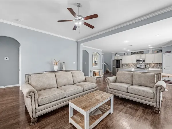 a living room with furniture and a view of kitchen