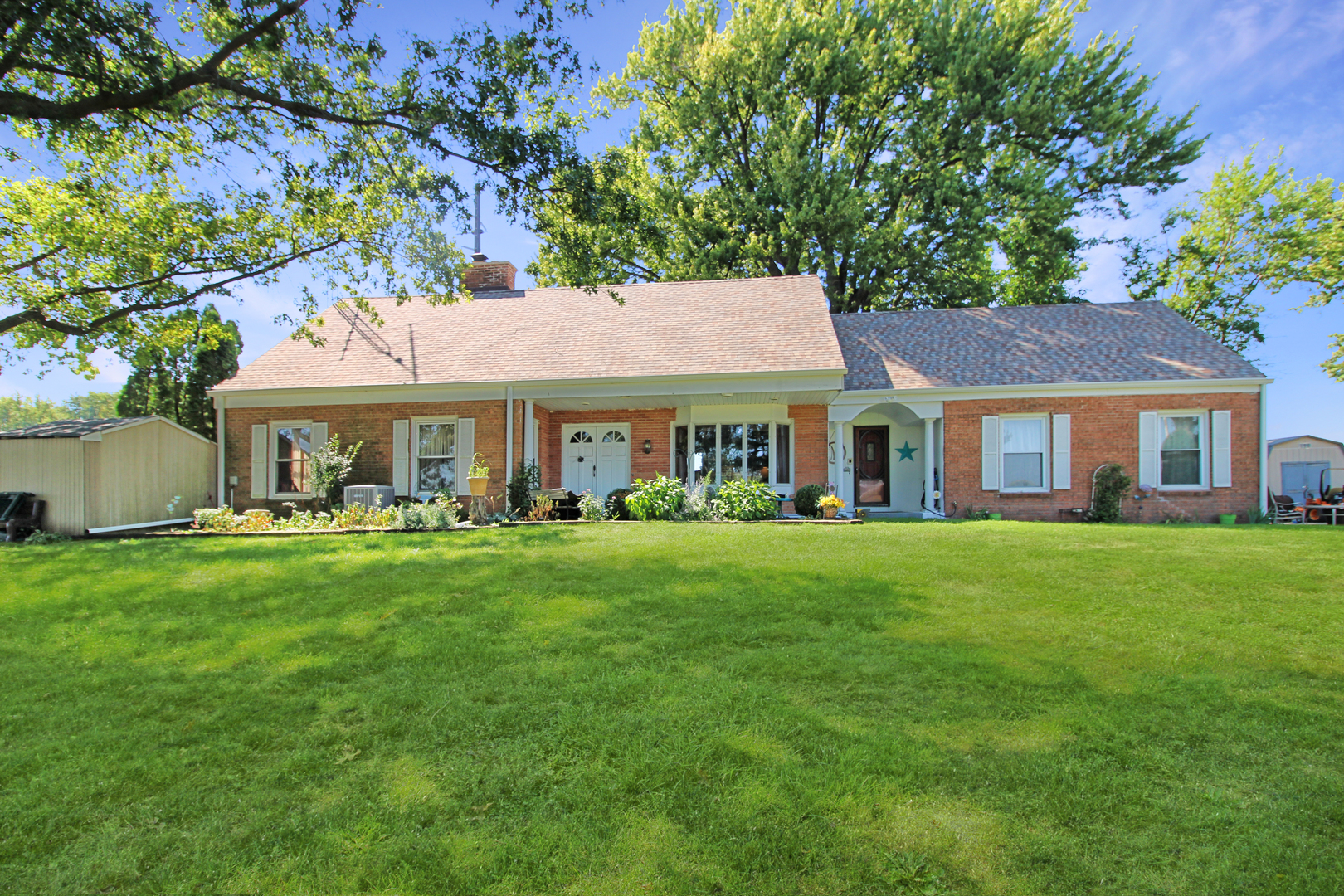 9033 Crego Road Waterman, IL 60556 - Photo 1 of 21 a front view of a house with a garden