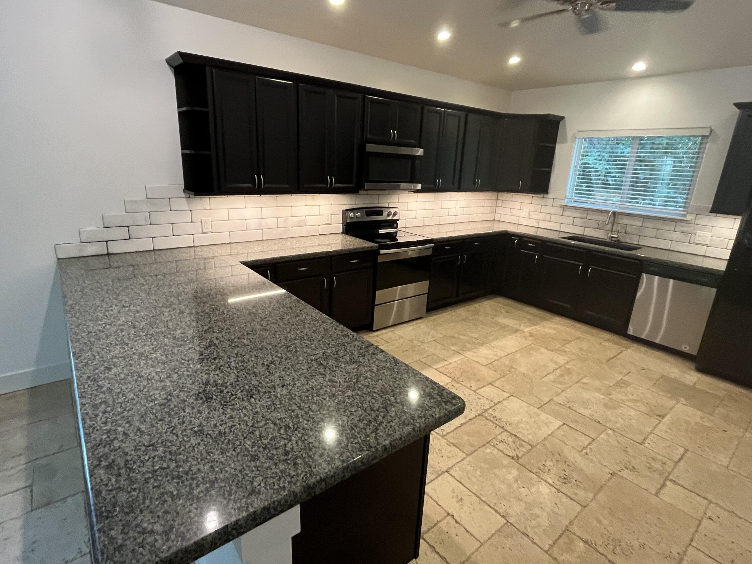 639 Cabrera Street Key Largo, FL 33037 - Photo 13 of 24 a kitchen with granite countertop a stove a sink and a microwave