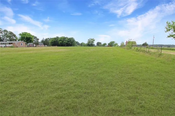 a view of a field with an trees in the background