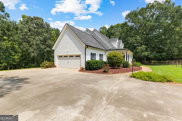 an aerial view of a residential houses with yard