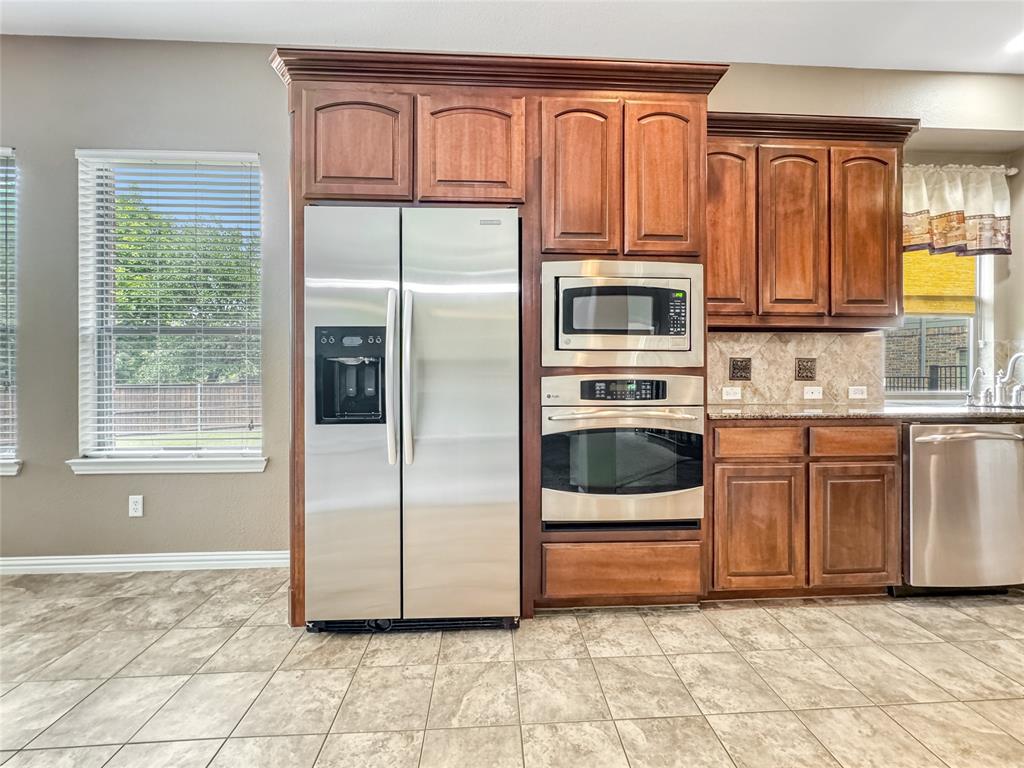401 Varnum Way Fairview, TX 75069 - Photo 8 of 33 a kitchen with granite countertop a refrigerator and cabinets