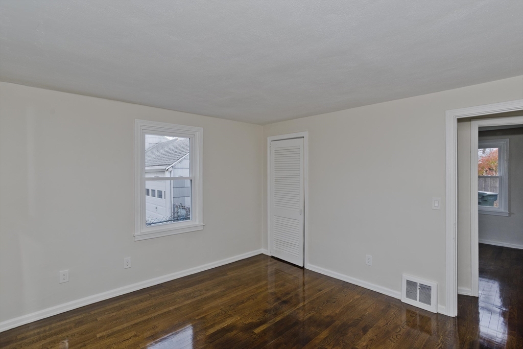 99 Massreco Street Springfield, MA 01109 - Photo 12 of 40 an empty room with wooden floor and windows