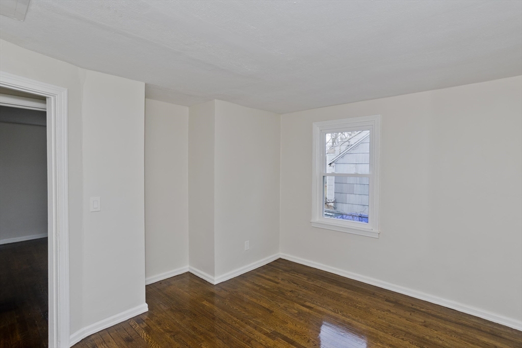99 Massreco Street Springfield, MA 01109 - Photo 14 of 40 a view of an empty room with wooden floor and a window
