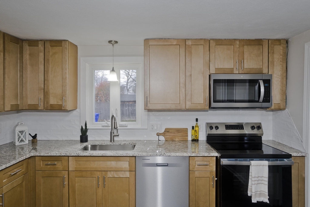 99 Massreco Street Springfield, MA 01109 - Photo 8 of 40 a kitchen with a sink a stove and cabinets
