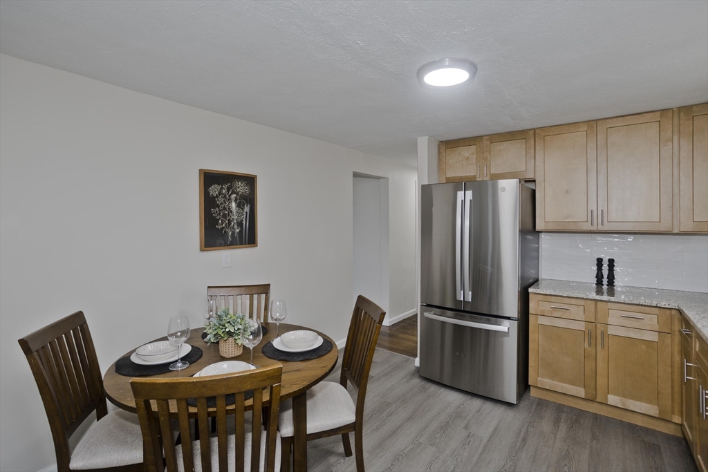 99 Massreco Street Springfield, MA 01109 - Photo 10 of 40 a kitchen with stainless steel appliances granite countertop a dining table chairs refrigerator and cabinets